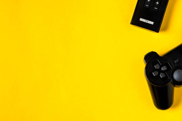 istock Game joystick and TV remote on a yellow background 1137113921