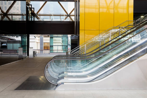 escalator in modern architecture, londres, angleterre - canary wharf railway station photos et images de collection