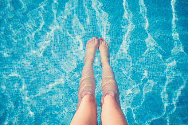 istock Woman relaxing by swimming pool with stretched legs 1137117874