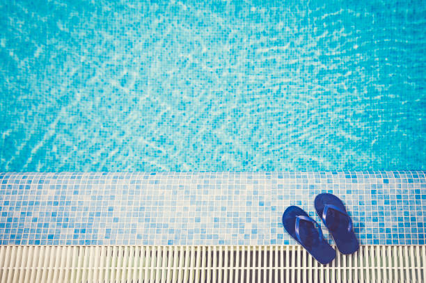 Top View Blue sandals / flip-flops by blue swimming pool in Spain