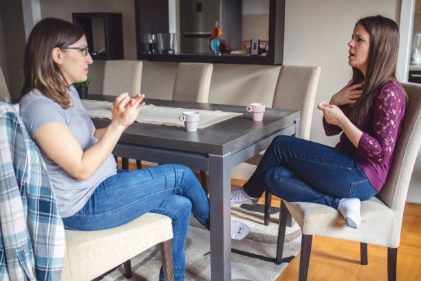 istock Young women drinking coffee while talking in hand signs 1137118797