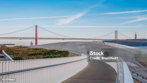 Pedestrian Bridge Leading To Landmark 25 Of April Bridge On Tagus River Lisbon Portugal Stock Photo - Download Image Now