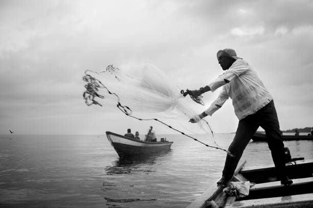the bait 2 La Barra, Juanchaco, Valle del Cauca, Colombia, on the morning of January 5, 2019, in this image, Rufino, a native fisherman, tries to catch many little fish with a net, his goal is to use them as bait in his day of fishing valle del cauca stock pictures, royalty-free photos & images
