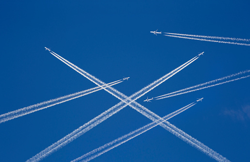Una gran cantidad de aviones de pasajeros en el aire, tráfico aéreo ocupado, viajando temporada alta comienza concepto. Aviones blancos contra el cielo azul.  Manipulación de fotos. photo