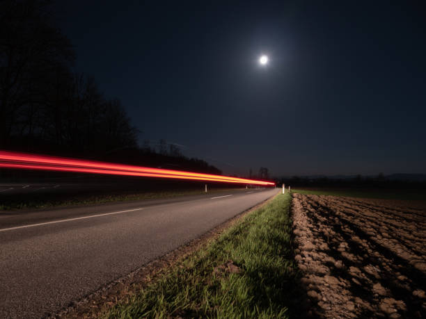 estrada secundária na noite iluminada por um carro de passagem - mountain austria street footpath - fotografias e filmes do acervo