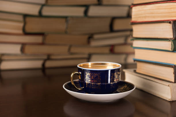 istock cup of tea and many books on the desktop 1137132537