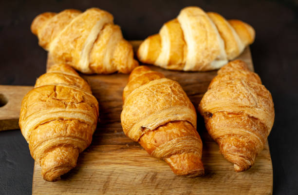 istock croissants on wooden cutting board, on background stone, top view 1137133041