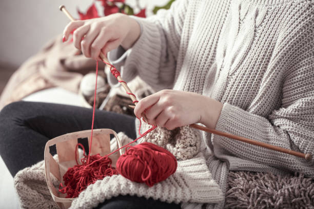 istock woman knits knitting needles on the couch 1137133614