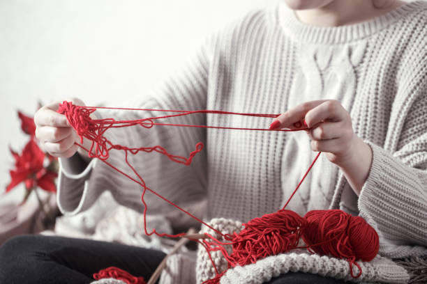 istock woman knits knitting needles on the couch 1137133616