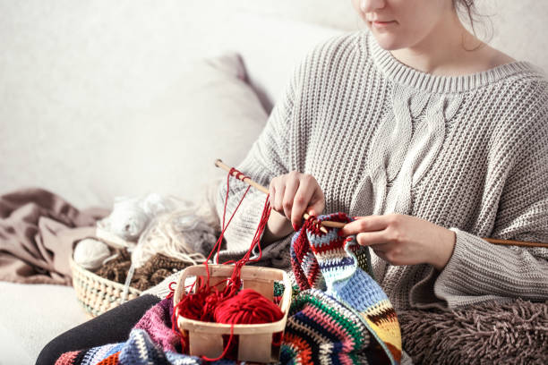 istock woman knits knitting needles on the couch 1137133617