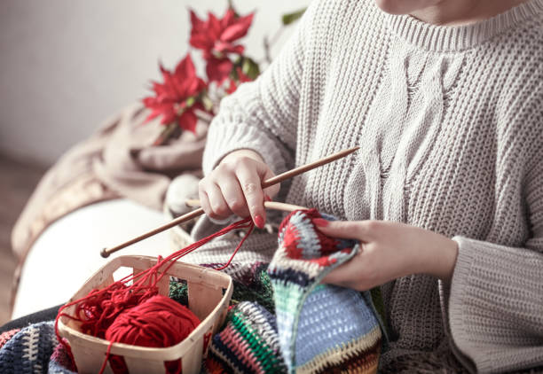 istock woman knits knitting needles on the couch 1137133619