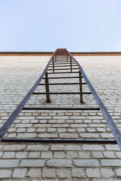 istock Old brick wall background with a metal staircase going into the sky 1137134155