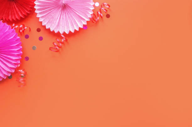 istock Paper flowers on orang table top view. Festive or party background. Flat lay style. Copy space for text. Birthday greeting card. 1137136985