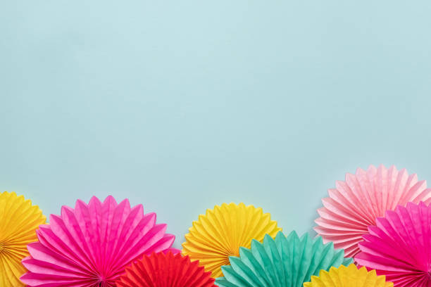 istock Different paper flowers on blue table top view. Festive or party background. Copy space for text. Birthday greeting card. 1137137124