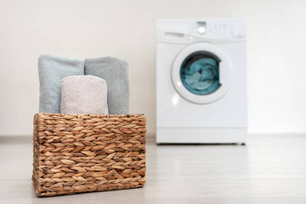 istock Laundry basket with clean and rolling towel standing inside bright light flat interior against blurred washing machine 1137138691