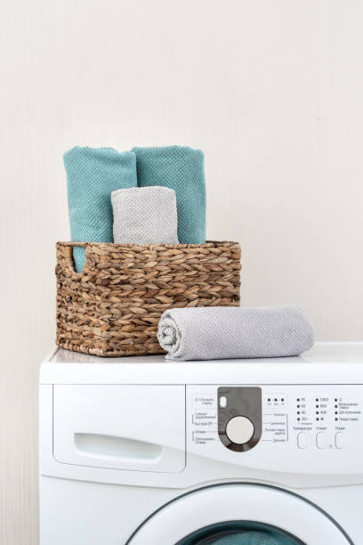 istock Vertical and close up photo of white washing machine standing inside light flat interior with clean towels after laundry 1137138797