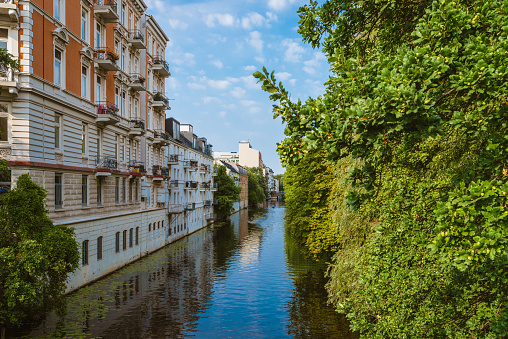 apartment buildings on bank of river or canal in residential district of Hamburg Eppendorf, Germany on sunny summer day