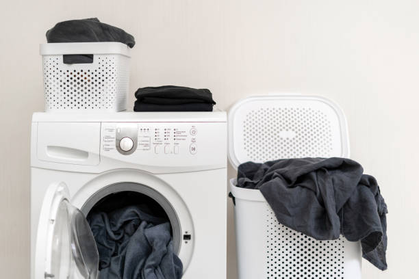istock Ready for laundry process. White washing machine with soft blanket inside standing near basket of clothes against wall inside flat with bright interior 1137140049