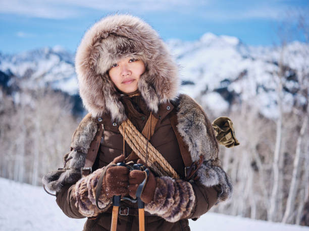 A Japanese woman wearing snowshoes, exploring the winter wilderness in the mountains.