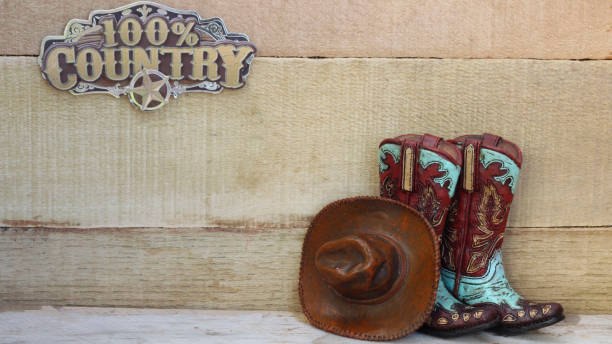 istock Cowboy boots and hat standing on a wood background 1137153744