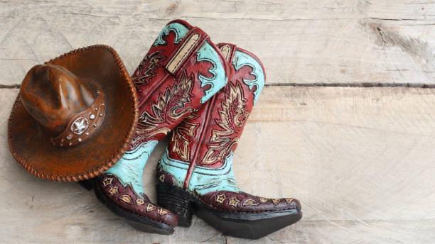 istock Cowboy boots and hat laying on a wood background 1137153745