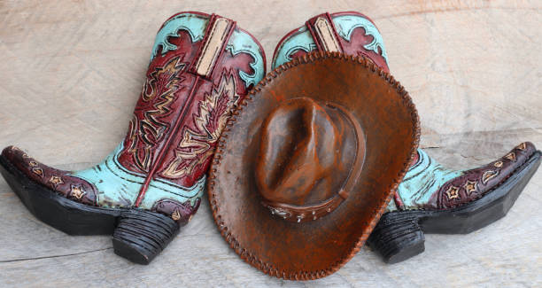 istock Cowboy boots and hat standing on a wood background 1137153747