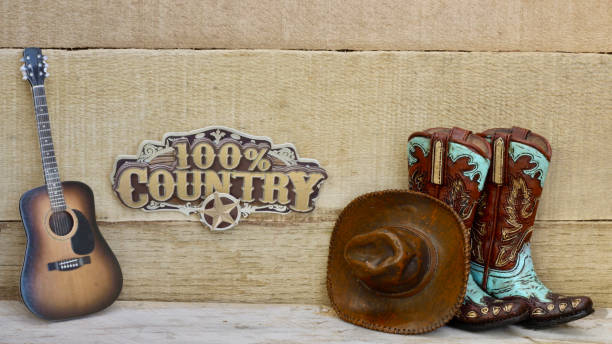 istock Cowboy boots and hat standing on a wood background 1137153792