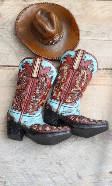 istock Cowboy boots and hat laying on a wood background 1137153992