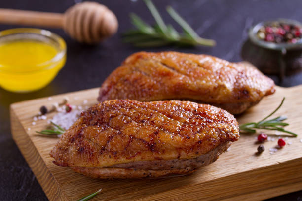 Duck breast, lavender honey and rosemary, served on chopping board Duck breast, lavender honey and rosemary, served on chopping board confit stock pictures, royalty-free photos & images