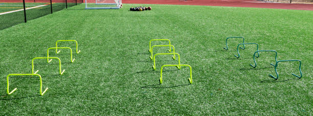 istock Small yellow plastic hurdles on a turf field 1137155911