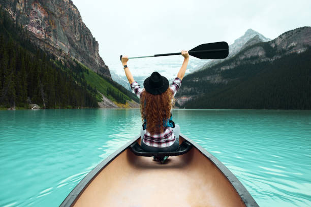 Mujer joven viajero en canoa disfrutando de vistas a la naturaleza - foto de stock