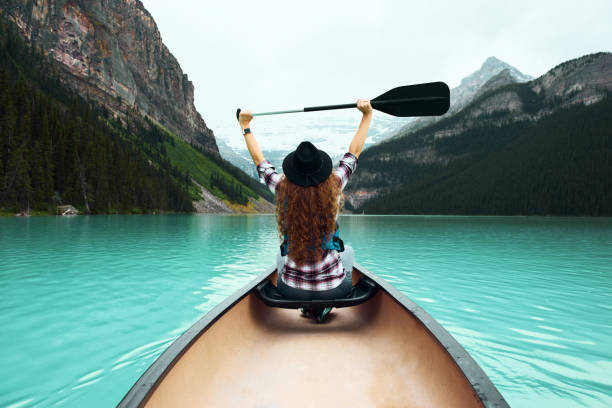 若い女性はカヌーで自然の景色を楽しむ旅行者 ストックフォト