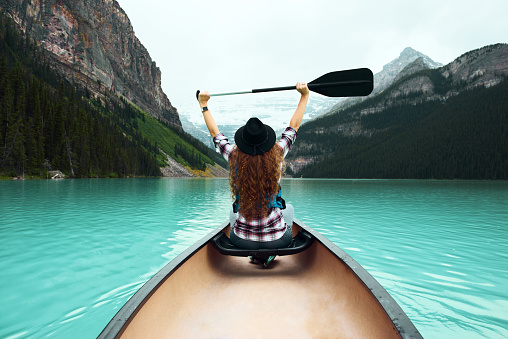 Young woman traveller on canoe enjoying nature views