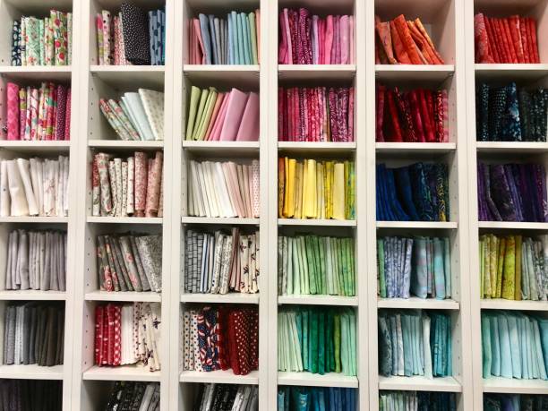 A shelving unit filled with colorful fat quarter fabric at a local quilt shop stock photo