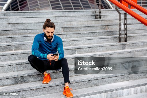 istock Using his smartphone after running 1137179062