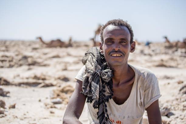Afar Salt Miner with Sharpened Teeth An ethnic Afar salt miner posing with his sharpened teeth in Ethiopia's Danakil Depression danakil depression stock pictures, royalty-free photos & images