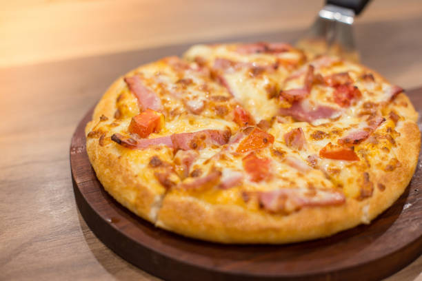 istock Pizza on wooden tray with warm light 1137191516