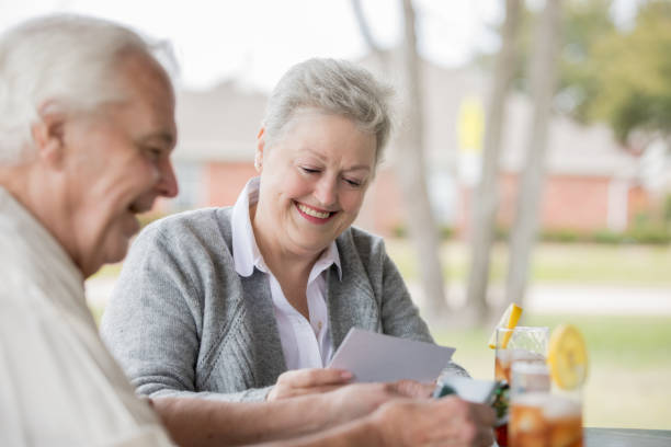 feliz pareja senior mirando fotografías juntas mientras disfrutas del día al aire libre - texas tea fotografías e imágenes de stock