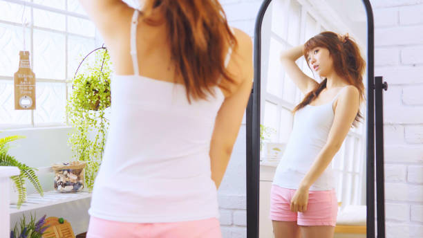 istock Beautiful Asian Girl Looking At The Mirror 1137213655