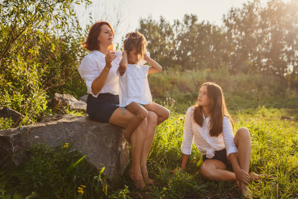 istock mom combs her daughter's hair in nature 1137218715