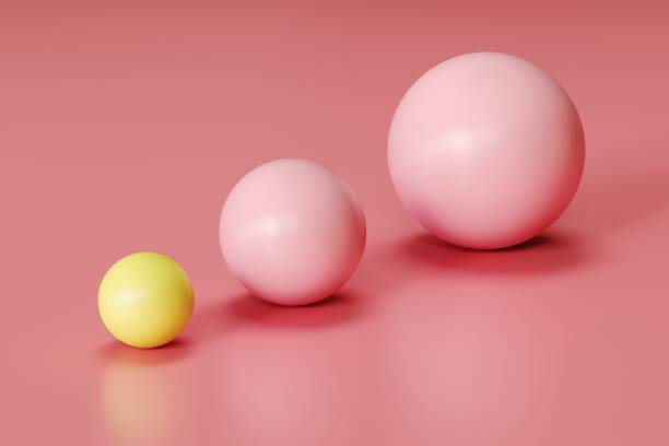 istock outstanding yellow sphere and pink spheres in different sizes on pink background. minimal concept idea 1137232443