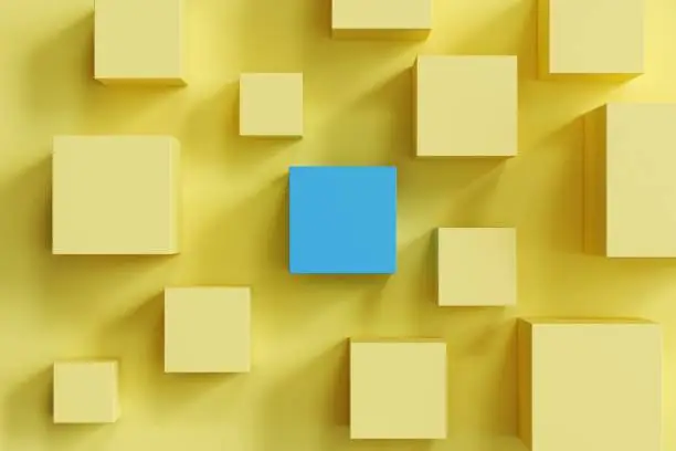 Photo of outstanding blue box among yellow boxes on yellow background. minimal flat lay contept