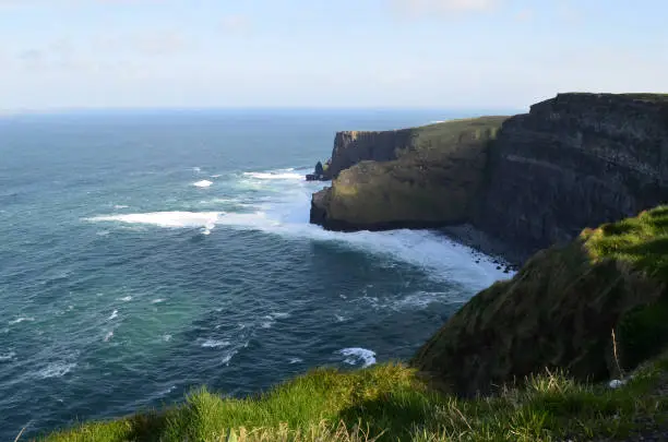 Waves foaming and crashing on the base of the Cliff's of Moher in Ireland.