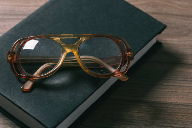 istock old book open on a wooden table with glasses 1137244341