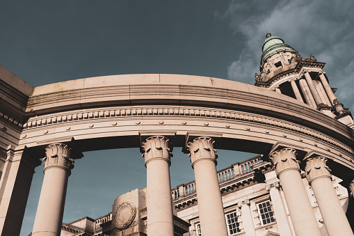 Neoclassical architectural columns holding up a curved lintel that surrounds a memorial to the First World War on the grounds of Belfast City Hall, Belfast, Northern Ireland.