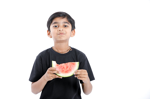 little Indian boy eating watermelon with multiple expressions