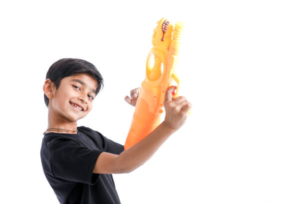 Indian Child playing holi with color gun