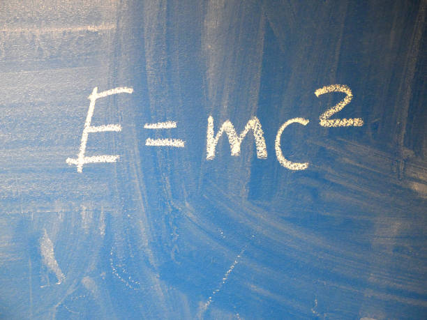istock Mathematical formula e=mc2 squared written on a blue, relatively dirty chalkboard by chalk. 1137259438