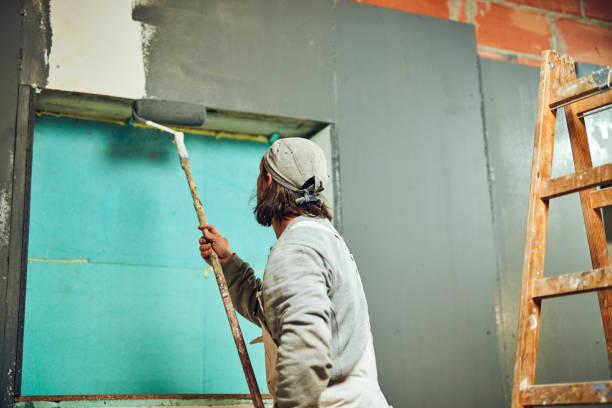 istock Painter painting walls with a extender roller indoors. 1137261331