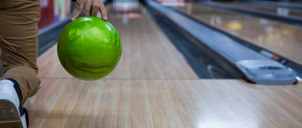 istock Man's hand holding a bowling ball ready to throw it. Young man playing bowling 1137261844